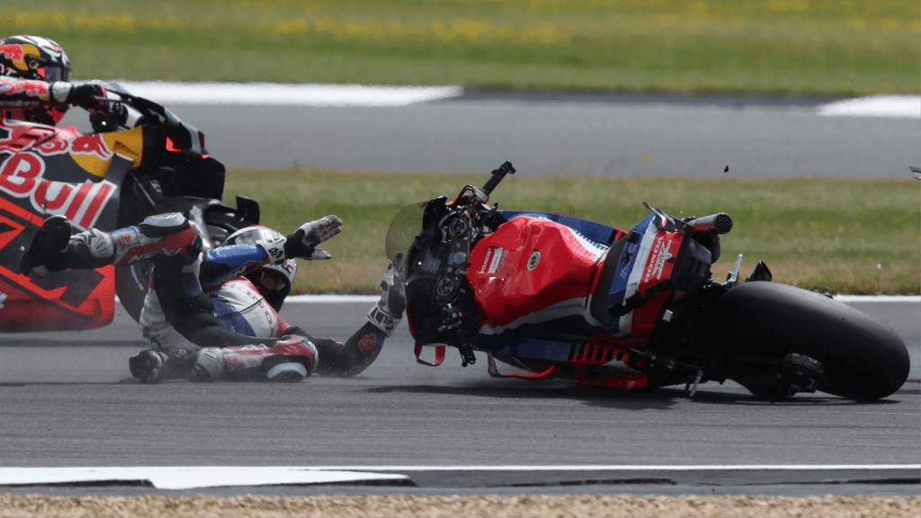 Un pilote tombé de sa moto sur la piste avec une autre moto en arrière-plan durant le Grand Prix MotoGP de Grande-Bretagne 2025 à Silverstone.