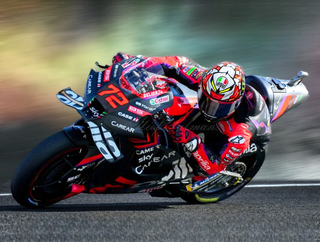 Un pilote de moto en pleine action sur un circuit, vêtu d'une combinaison rouge et noire, avec le numéro 72 visible sur sa moto.