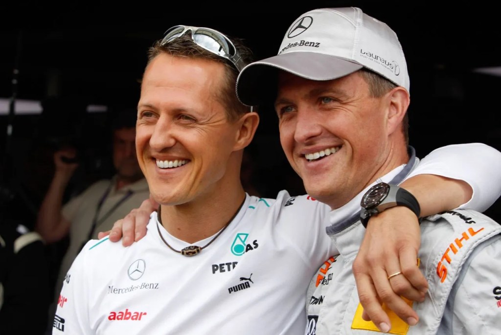 Deux pilotes de Formule 1 souriants posant ensemble lors d'un événement.