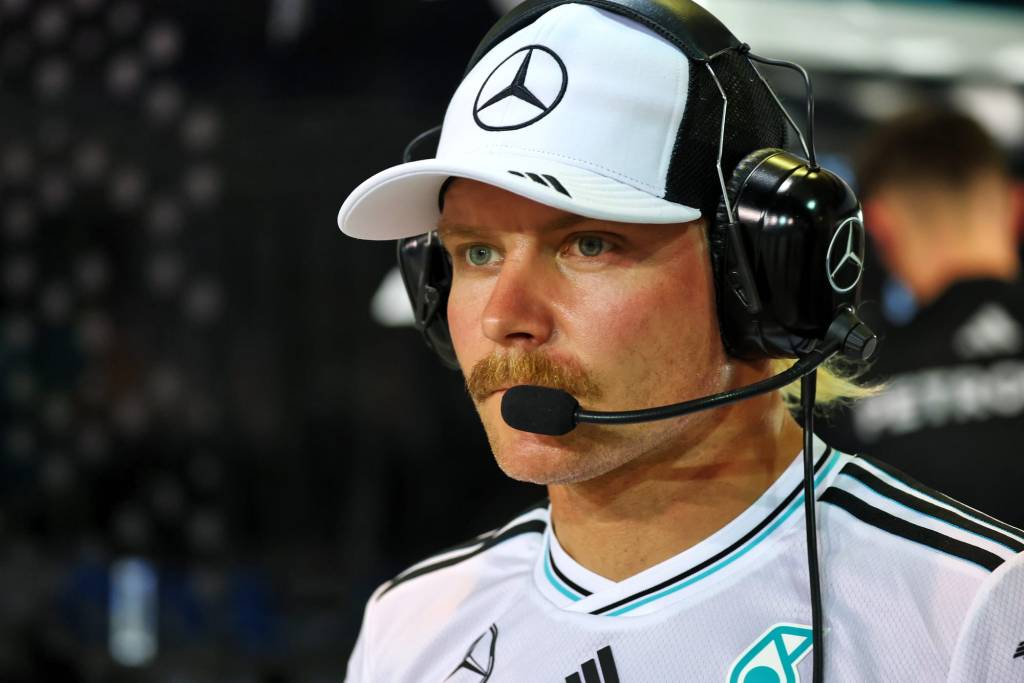 Valtteri Bottas, pilote de réserve chez Mercedes, portant un casque de communication et un uniforme de l'équipe, regarde attentivement lors d'une session de simulateur.