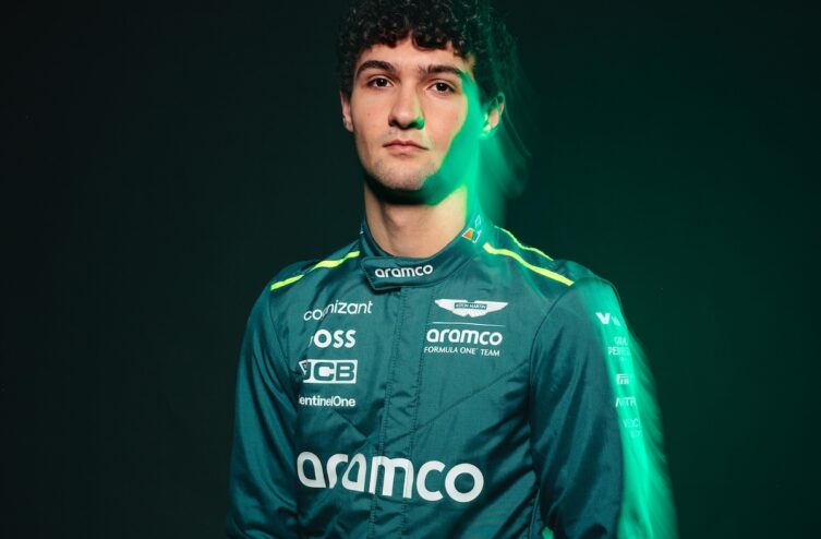 Portrait de José María Navalón 'Mari' Boya, pilote de la Driver Academy d'Aston Martin, portant une combinaison de course vert foncé avec le logo de l'équipe, sur fond sombre.
